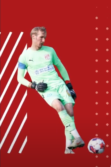 Goalkeeper in green kit kicking a ball