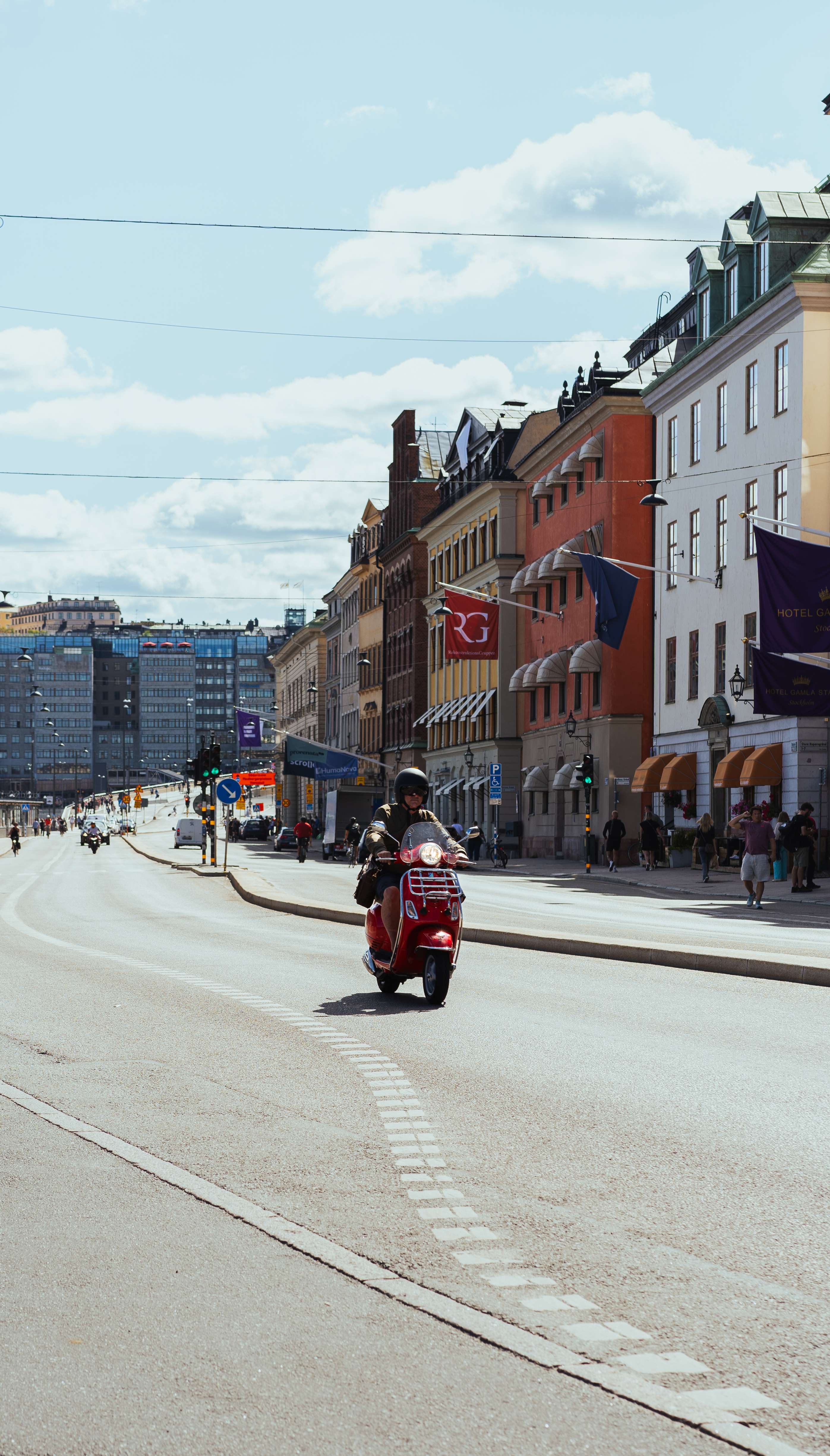 Person riding a red scooter in a European city